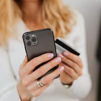 close up shot of a person holding a credit card and a smartphone